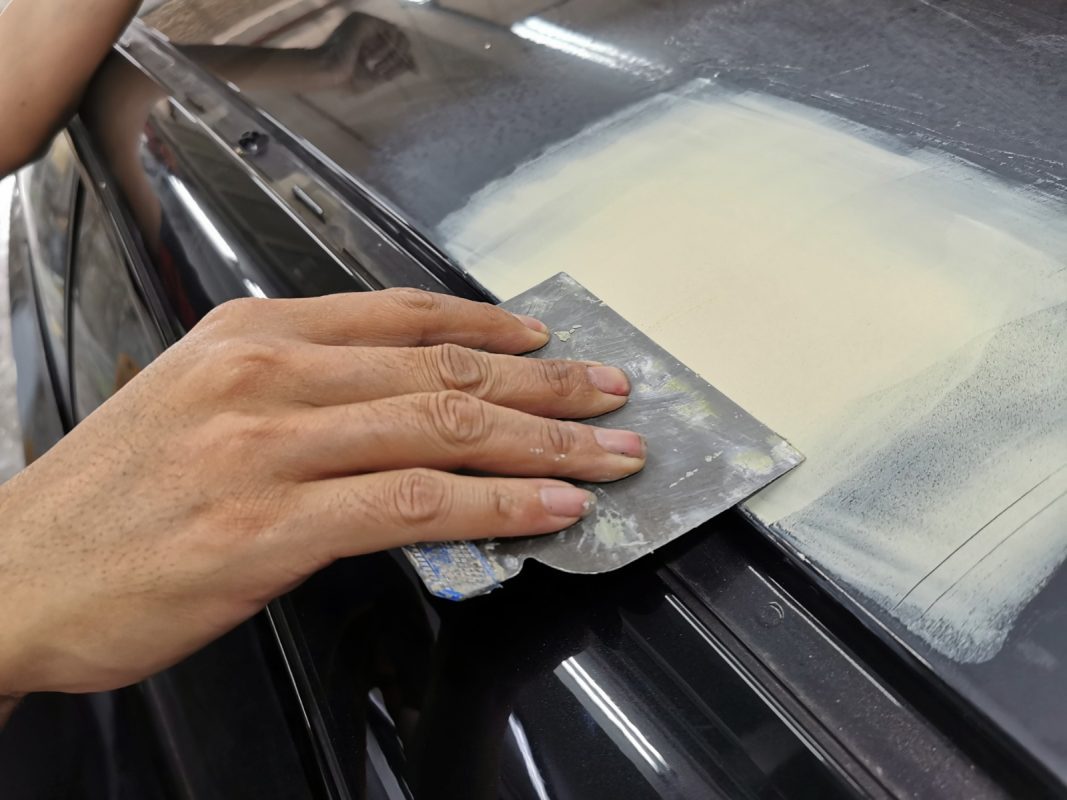 The car's surface inspected and patched where the paintwork was imperfect.