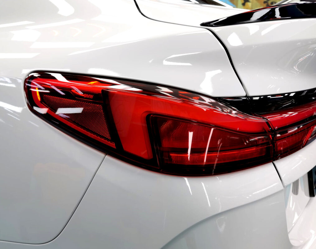 The coated bonnet of the BMW 2 Series under workshop lighting.