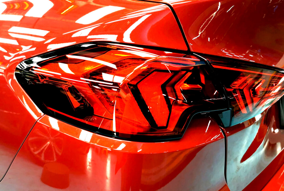 The coated bonnet of the BMW 2 Series under workshop lighting.