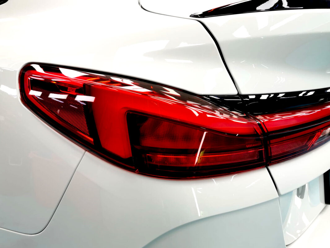 The coated bonnet of the BMW 2 Series under workshop lighting.