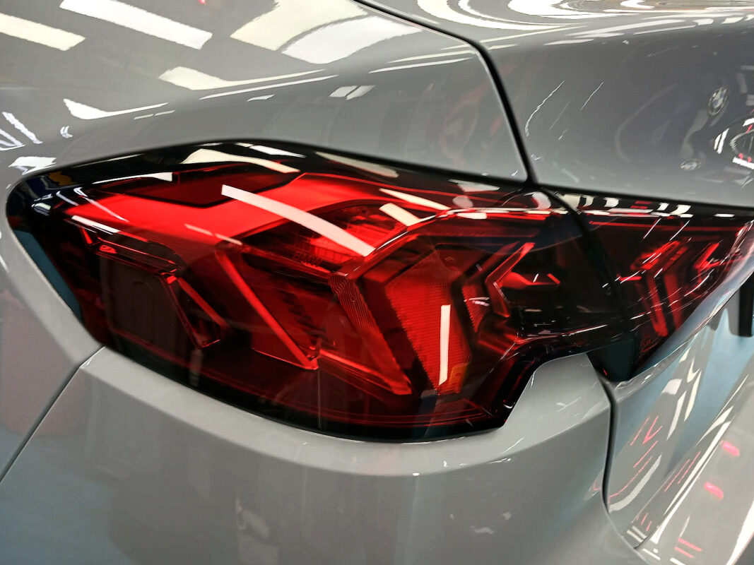 The coated bonnet of the BMW 2 Series under workshop lighting.