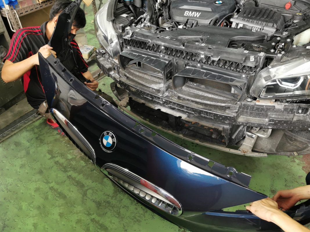 Previously removed car parts being refitted onto the BMW 2 Series.