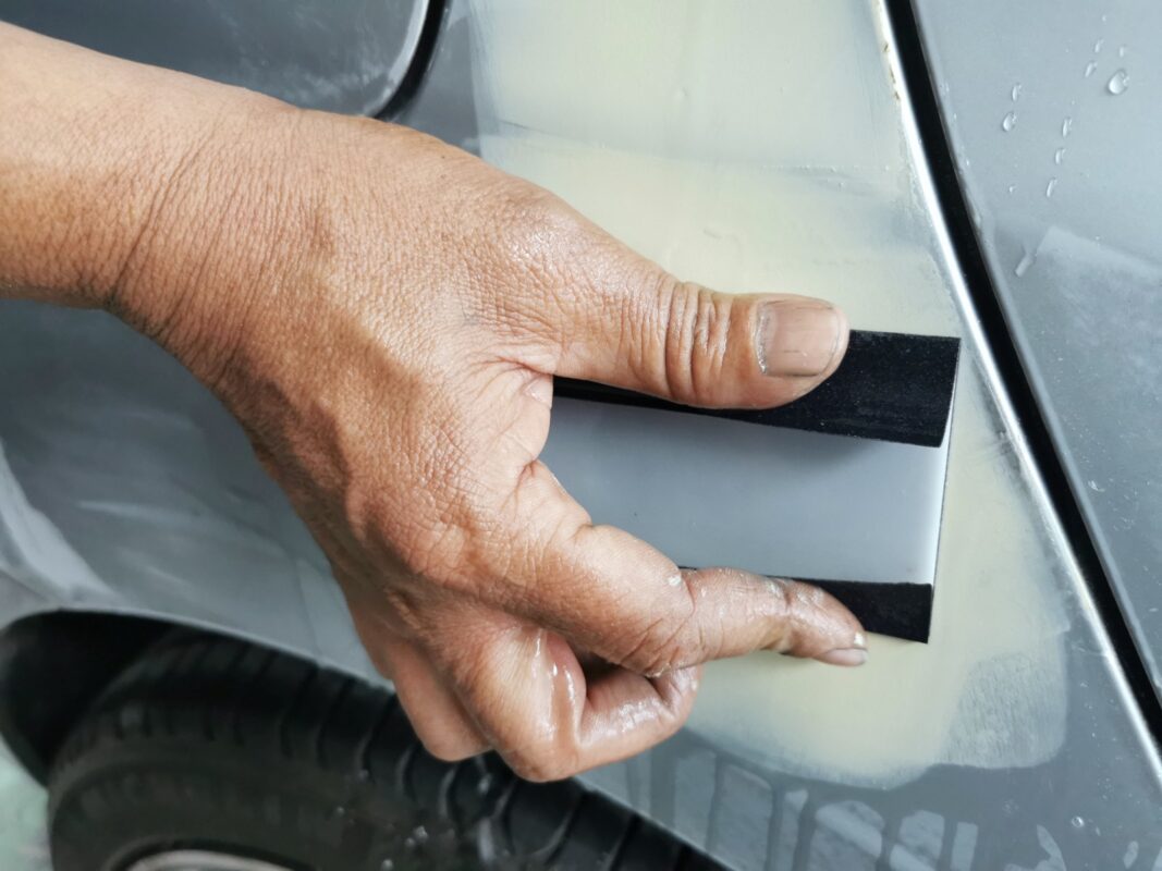 Refitting window trim on the BMW 2 Series after painting.