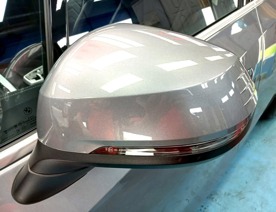 Grey wing mirror on the 2 Series with reflections in the paint.