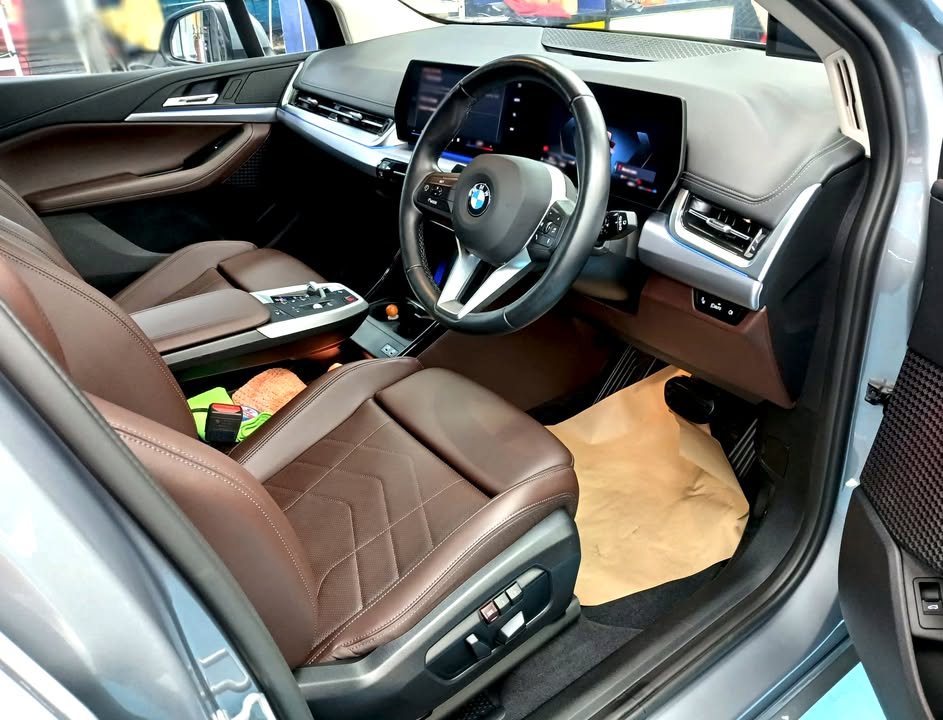 Front cabin of the 2 Series with brown leather seats and curved display.