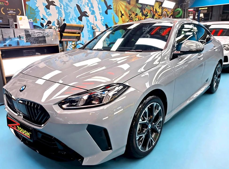 Front three-quarter view of a grey BMW 2 Series in the Revol Carz hall after coating.