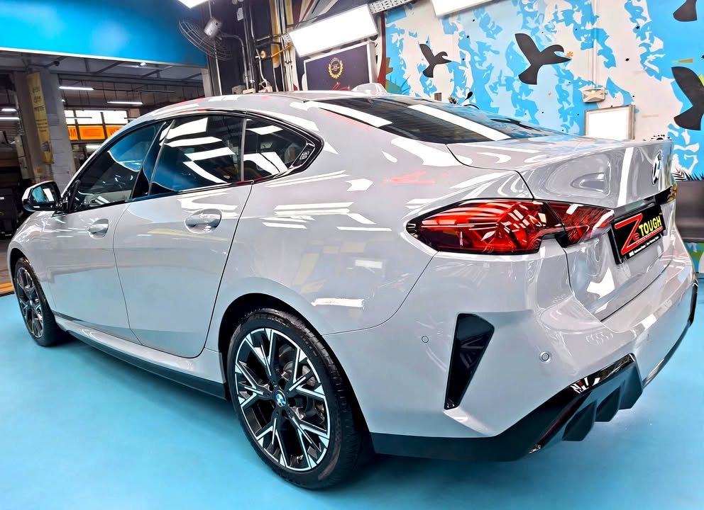 Rear three-quarter view of the grey BMW 2 Series showing the tail lights.