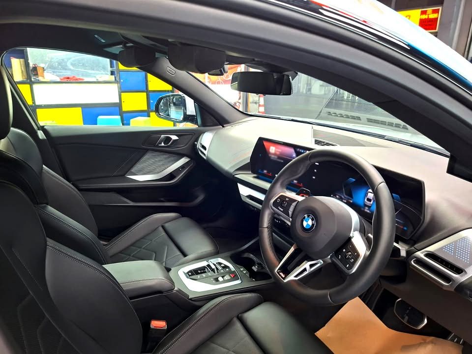 Black leather seats, steering wheel and curved screen inside the 2 Series.
