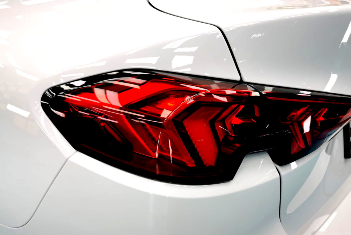 The coated bonnet of the BMW 216 GC under workshop lighting.