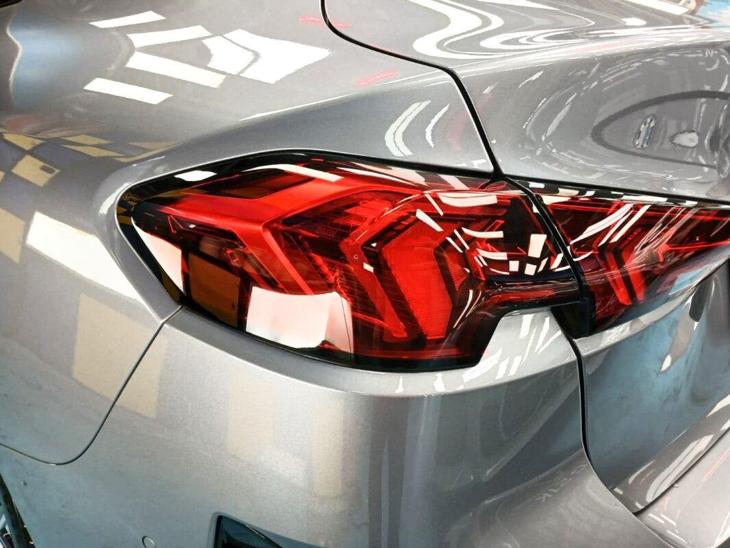 The coated bonnet of the BMW 216 GC under workshop lighting.
