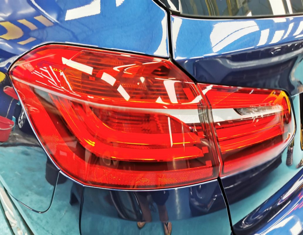 The coated bonnet of the BMW 216D under workshop lighting.