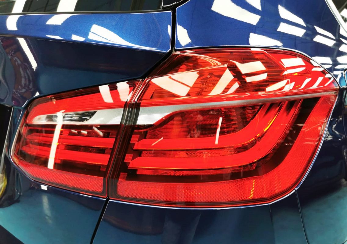 The coated bonnet of the BMW 216D under workshop lighting.
