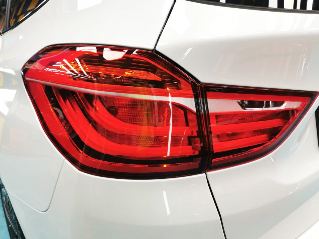 The coated bonnet of the BMW 216D under workshop lighting.