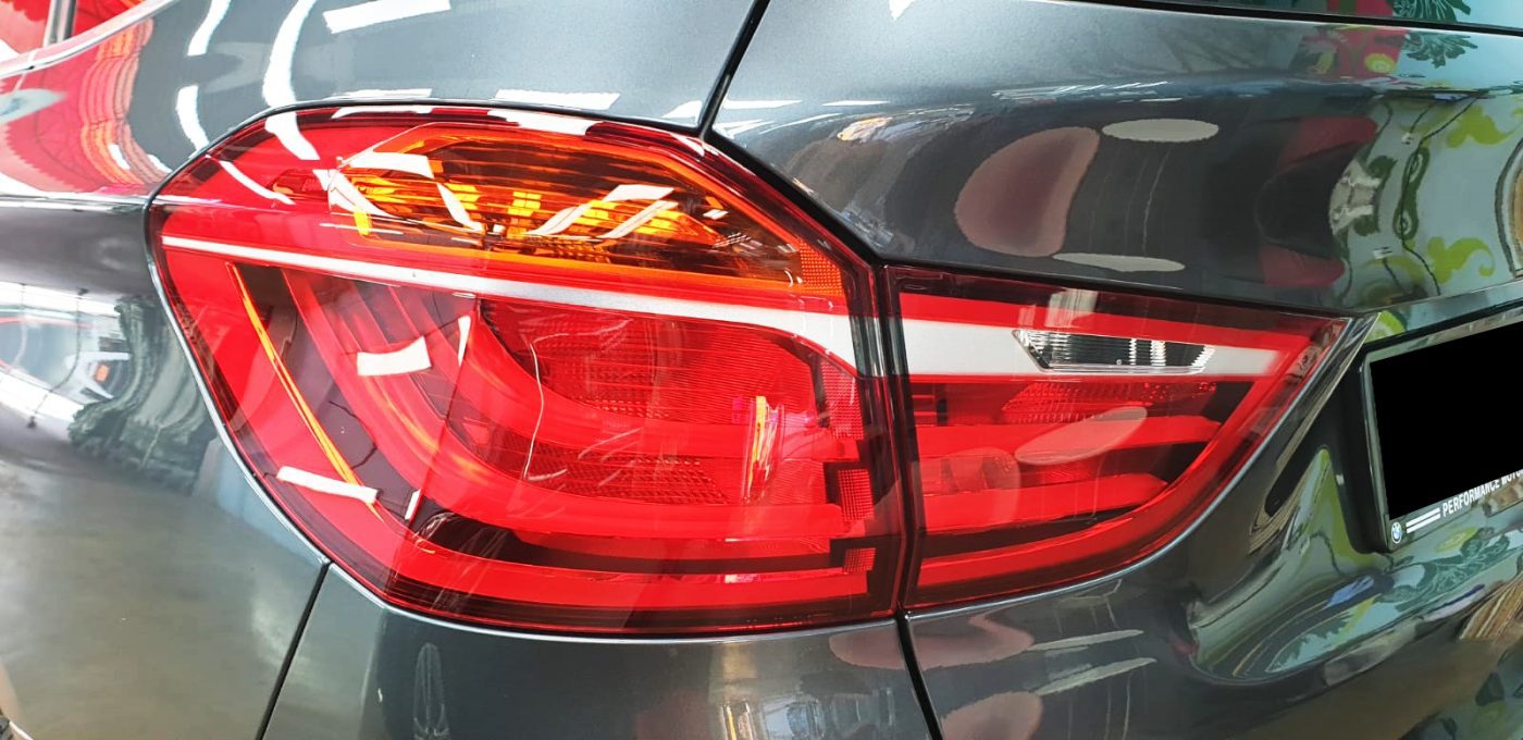 The coated bonnet of the BMW 216GT under workshop lighting.