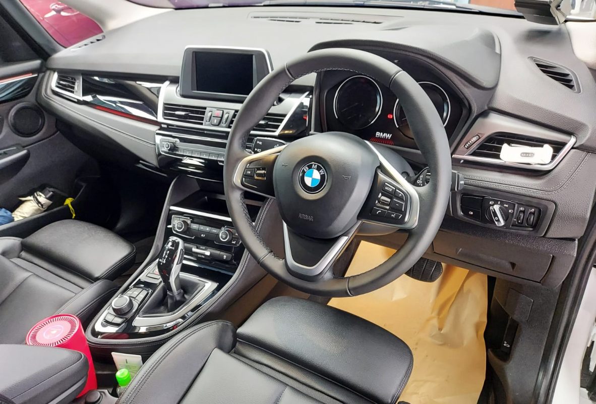The BMW 216i parked in the workshop, freshly coated.