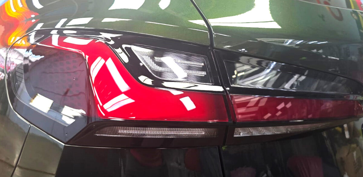 The coated bonnet of the BMW 216i under workshop lighting.