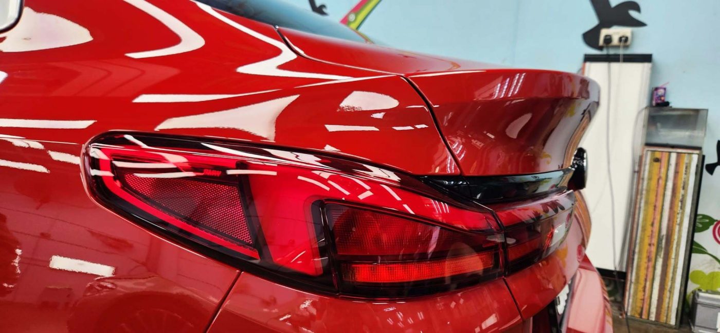 The coated bonnet of the BMW 216i GC under workshop lighting.