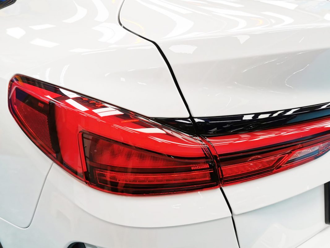 The coated bonnet of the BMW 216i GC under workshop lighting.