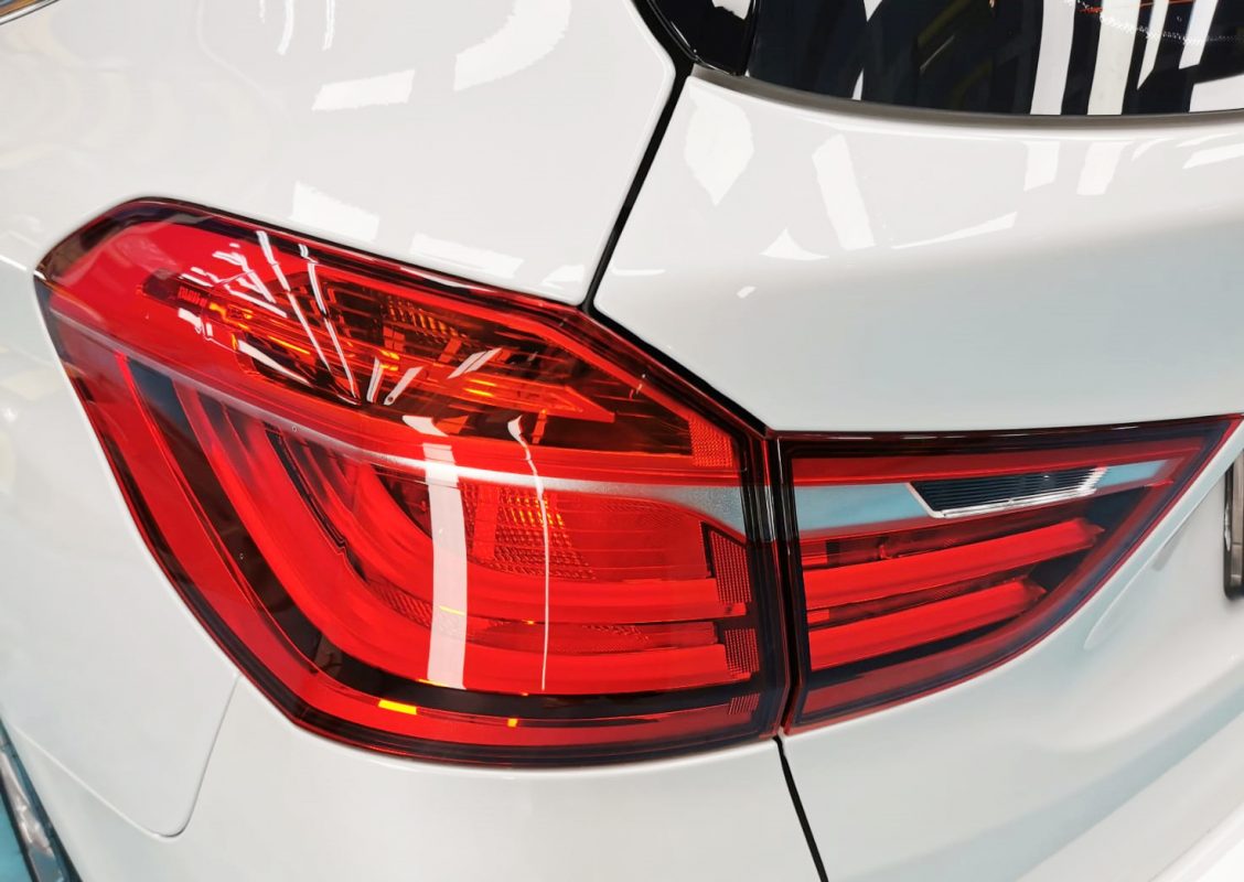 The coated bonnet of the BMW 216i Gran Tourer under workshop lighting.