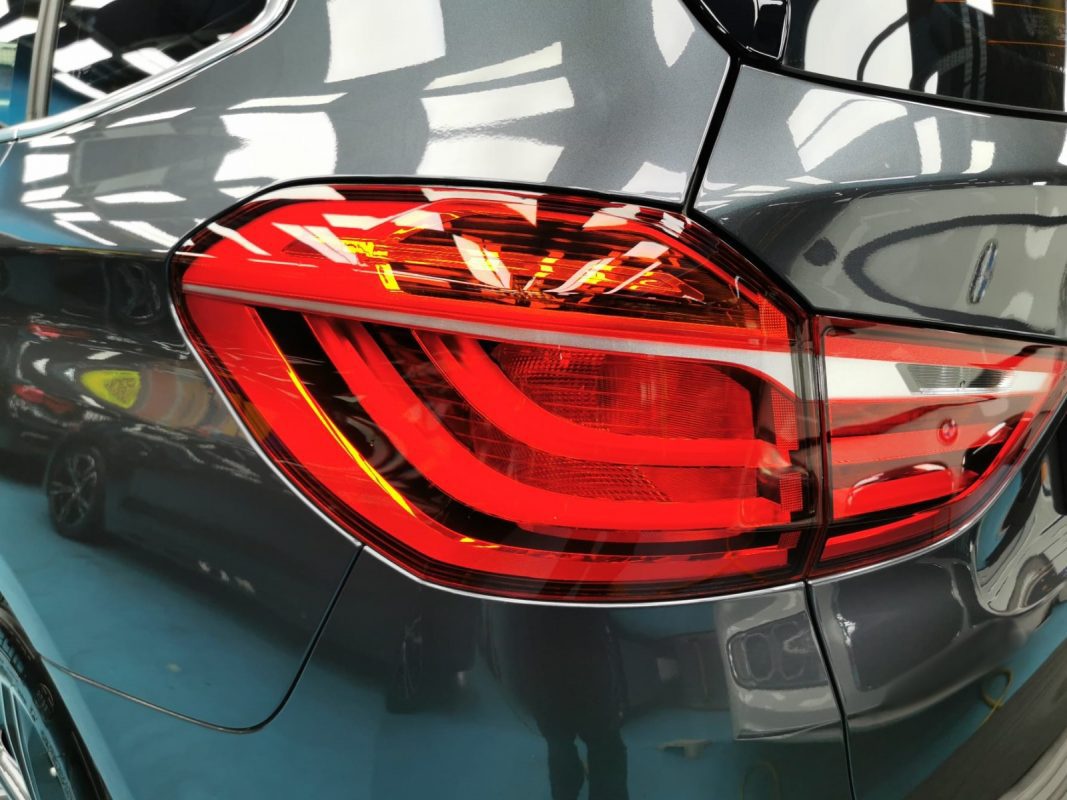 The coated bonnet of the BMW 218 under workshop lighting.