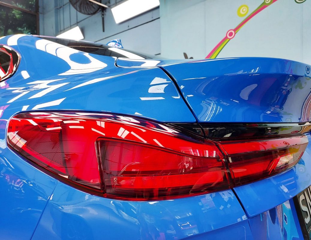 The coated bonnet of the BMW 218 under workshop lighting.