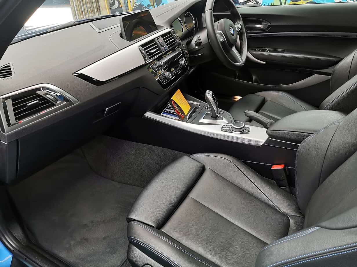 The BMW 218i parked in the workshop, freshly coated.