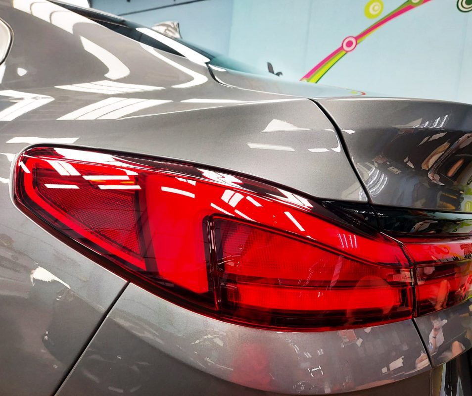 The coated bonnet of the BMW 218i GC under workshop lighting.