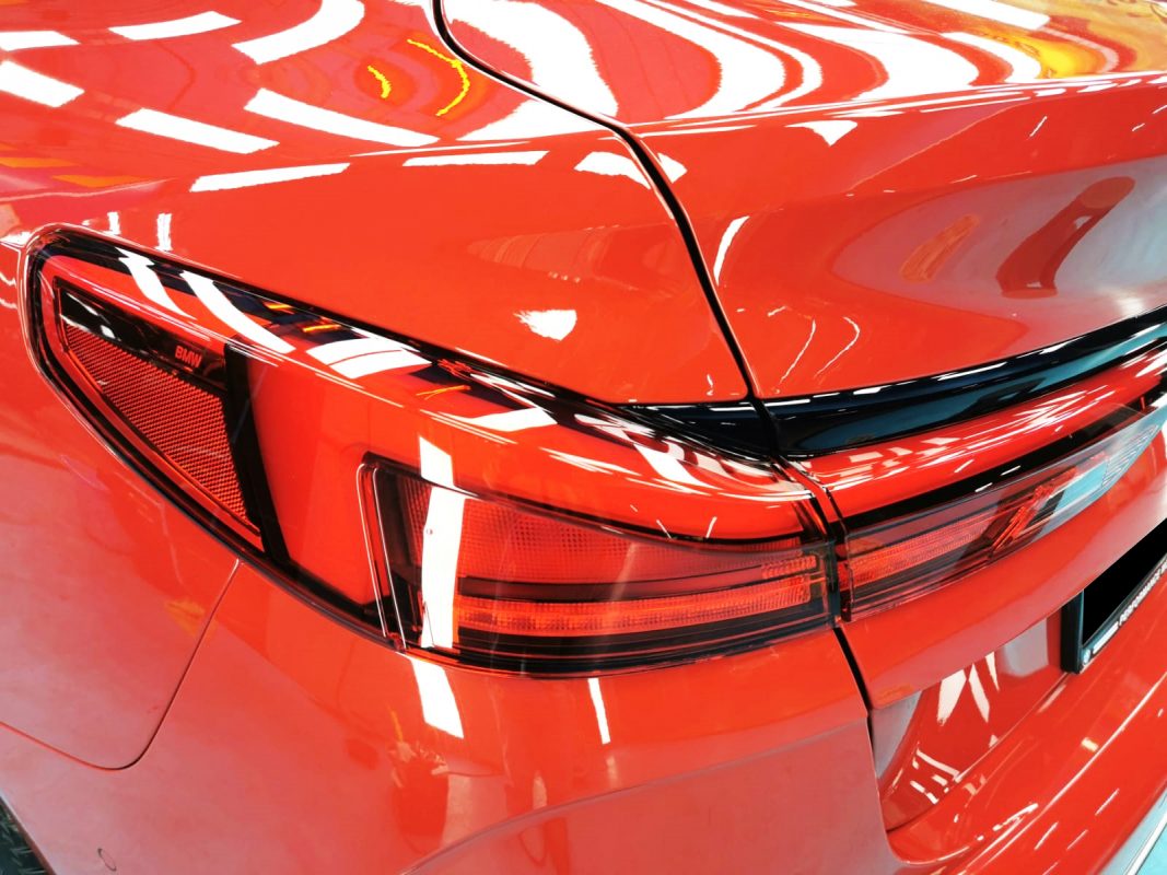 The coated bonnet of the BMW 218i under workshop lighting.
