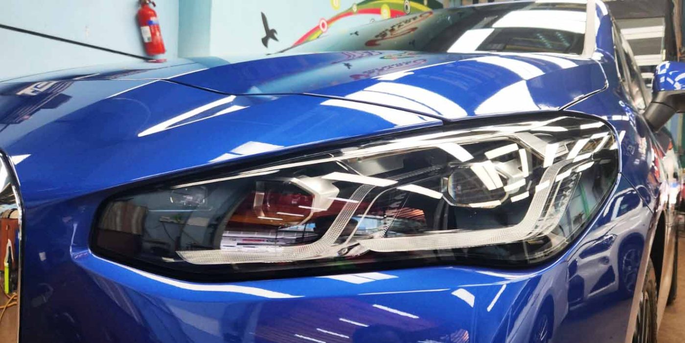 The 218i's coated paintwork holding clean reflections.
