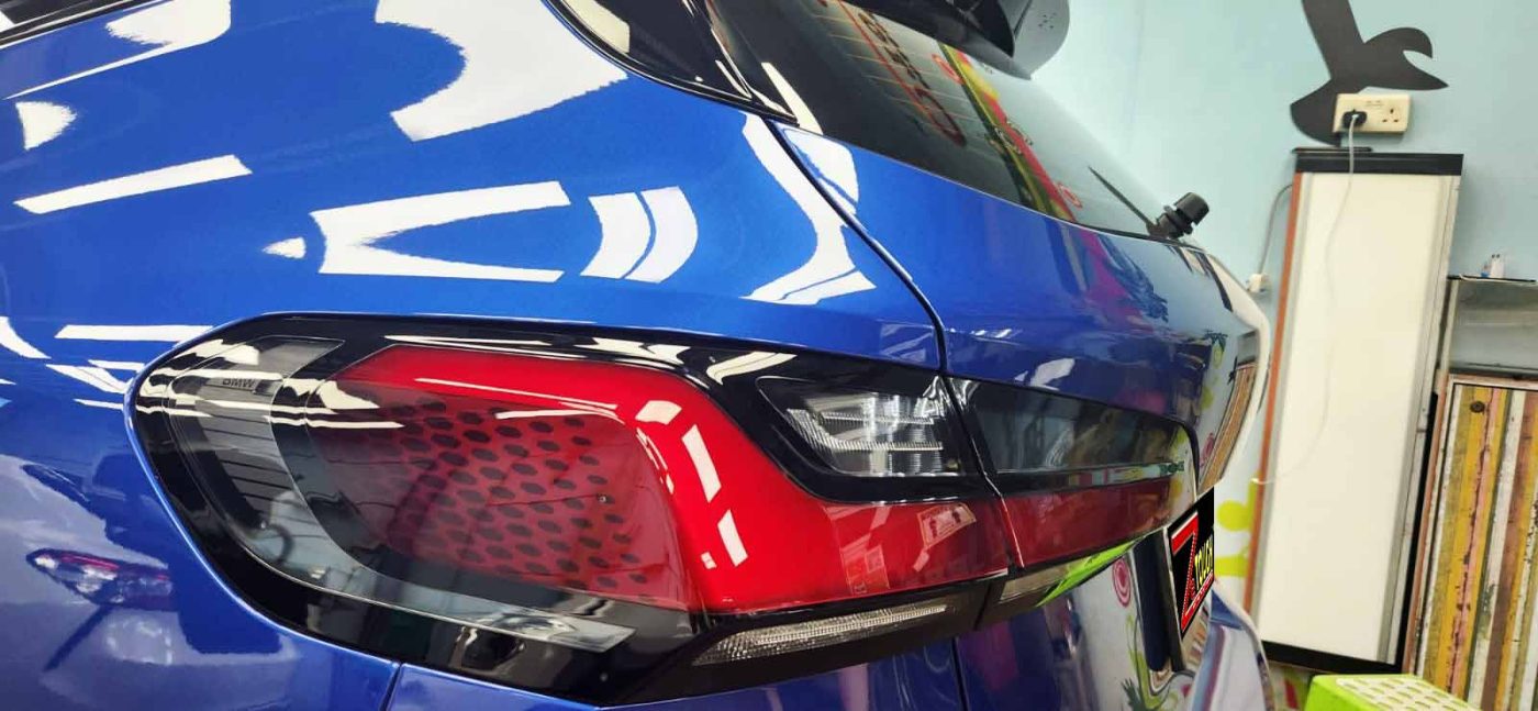 The coated bonnet of the BMW 218i under workshop lighting.