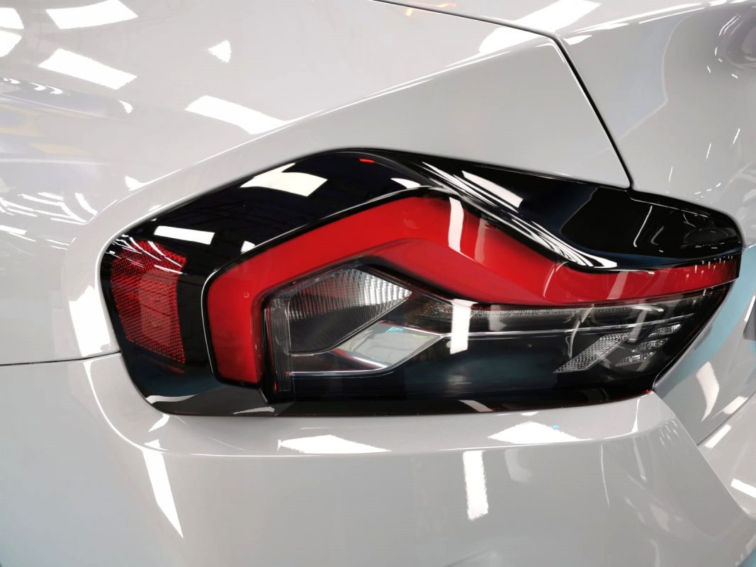 The coated bonnet of the BMW 220i under workshop lighting.