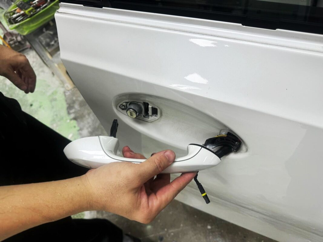 A door handle removed as the BMW 3 Series is stripped down for the respray.