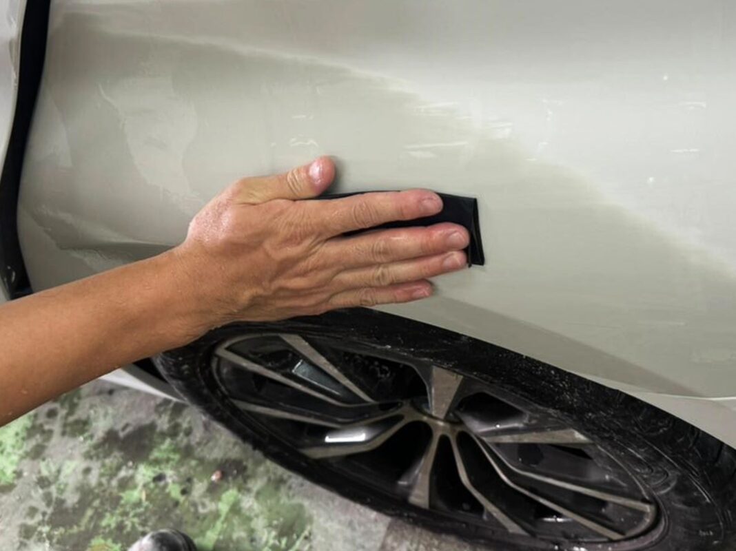 Wet-sanding a primed panel on the BMW 3 Series smooth.