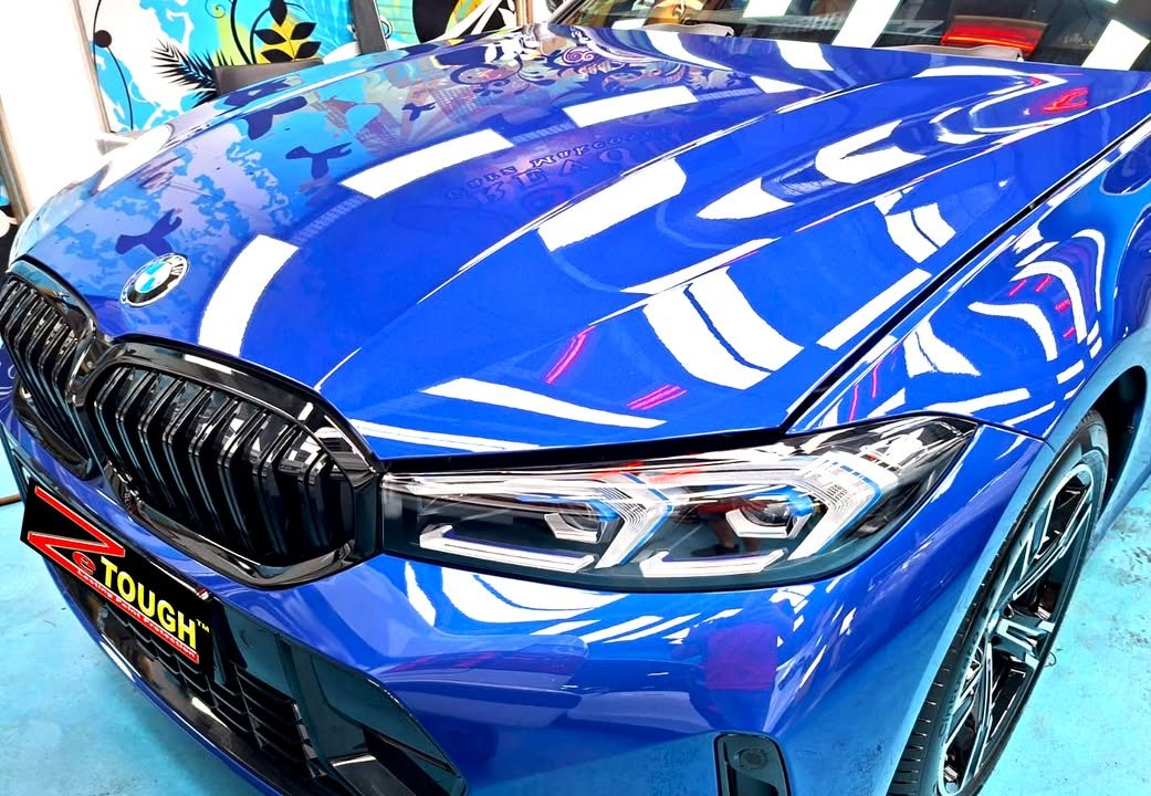 Close-up of the black kidney grille and headlamp on the blue front end.