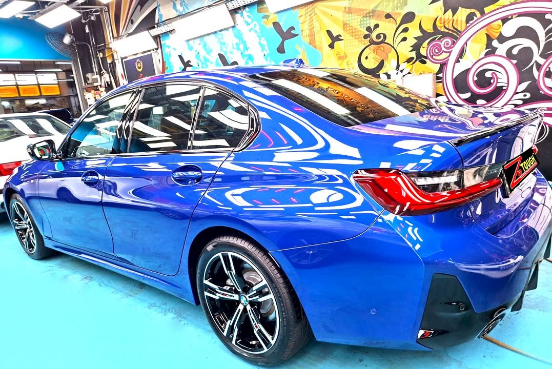 Rear three-quarter view of the blue BMW 3 Series.