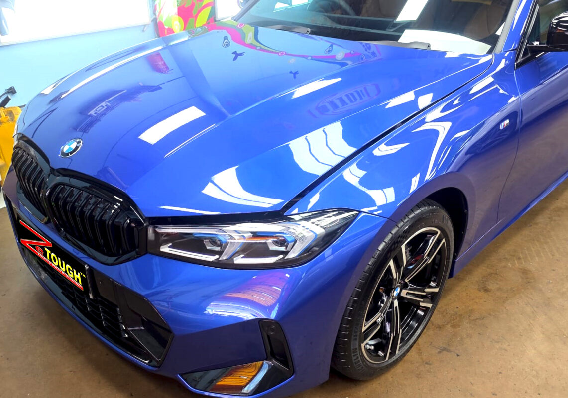 The BMW 3 Series's coated paintwork under workshop lighting.