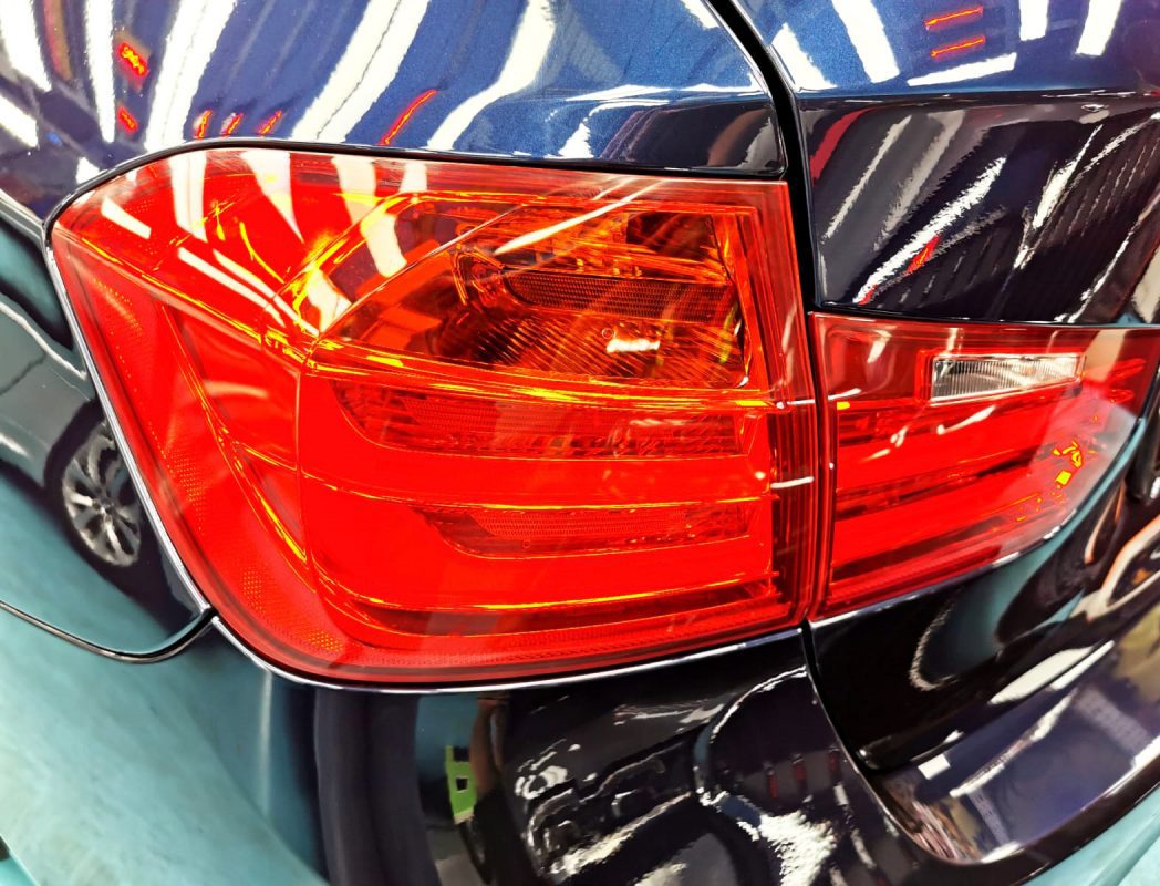 The coated bonnet of the BMW 316i under workshop lighting.