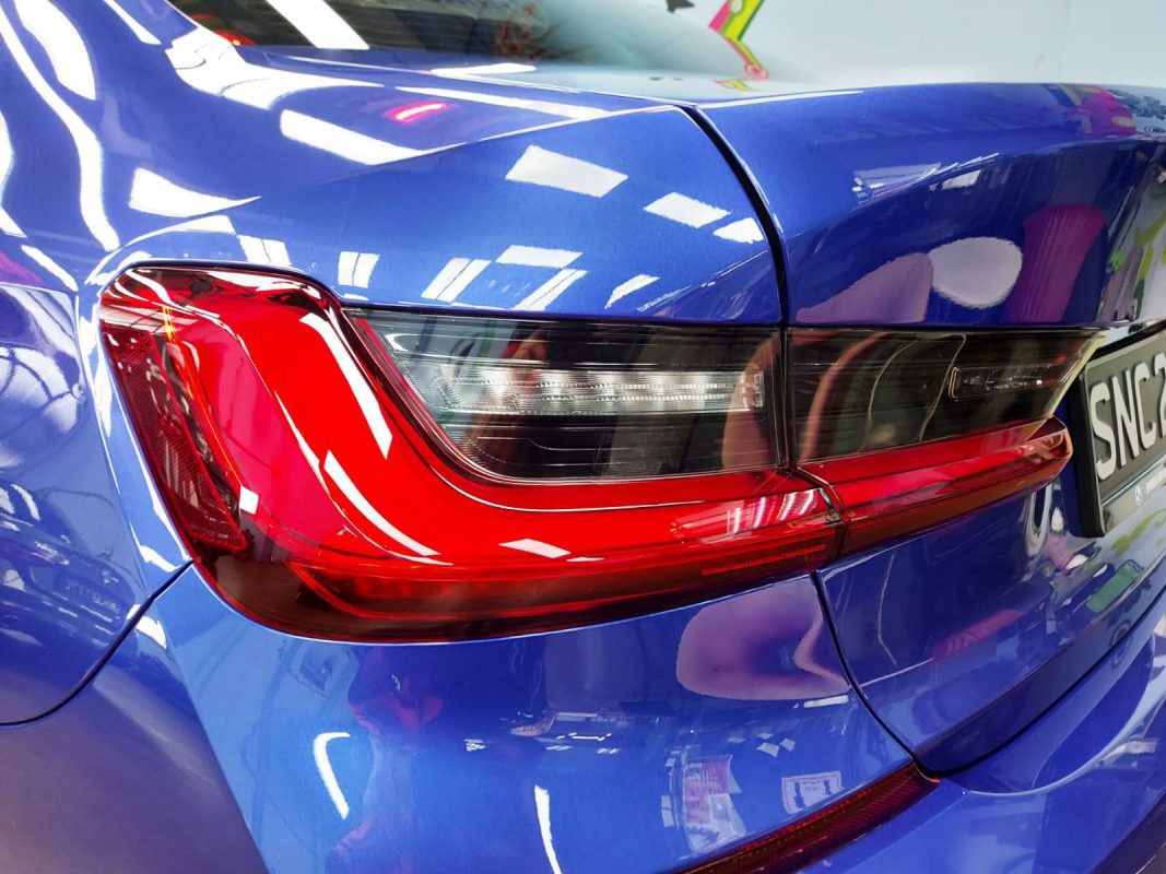 The coated bonnet of the BMW 318 under workshop lighting.