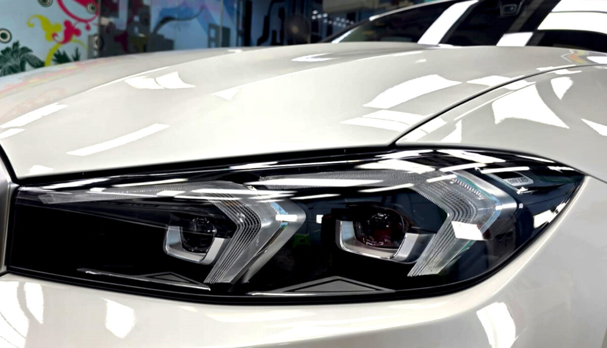 The 318i's coated paintwork showing clean reflections.