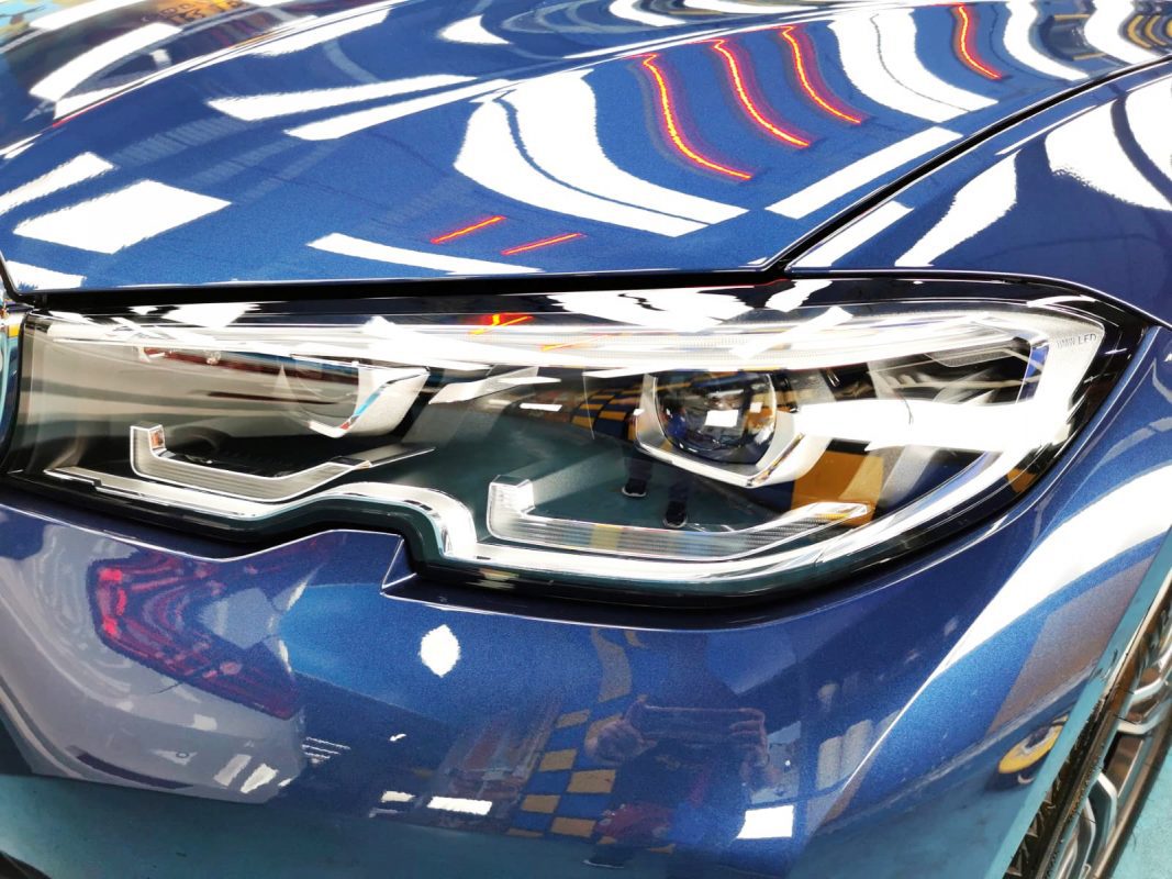 The 318i's coated paintwork showing clean reflections.