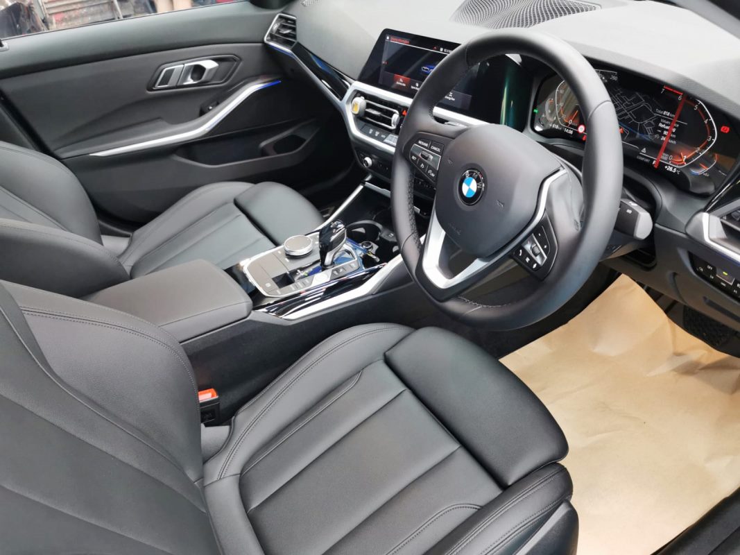 The BMW 318i parked in the workshop, freshly coated.