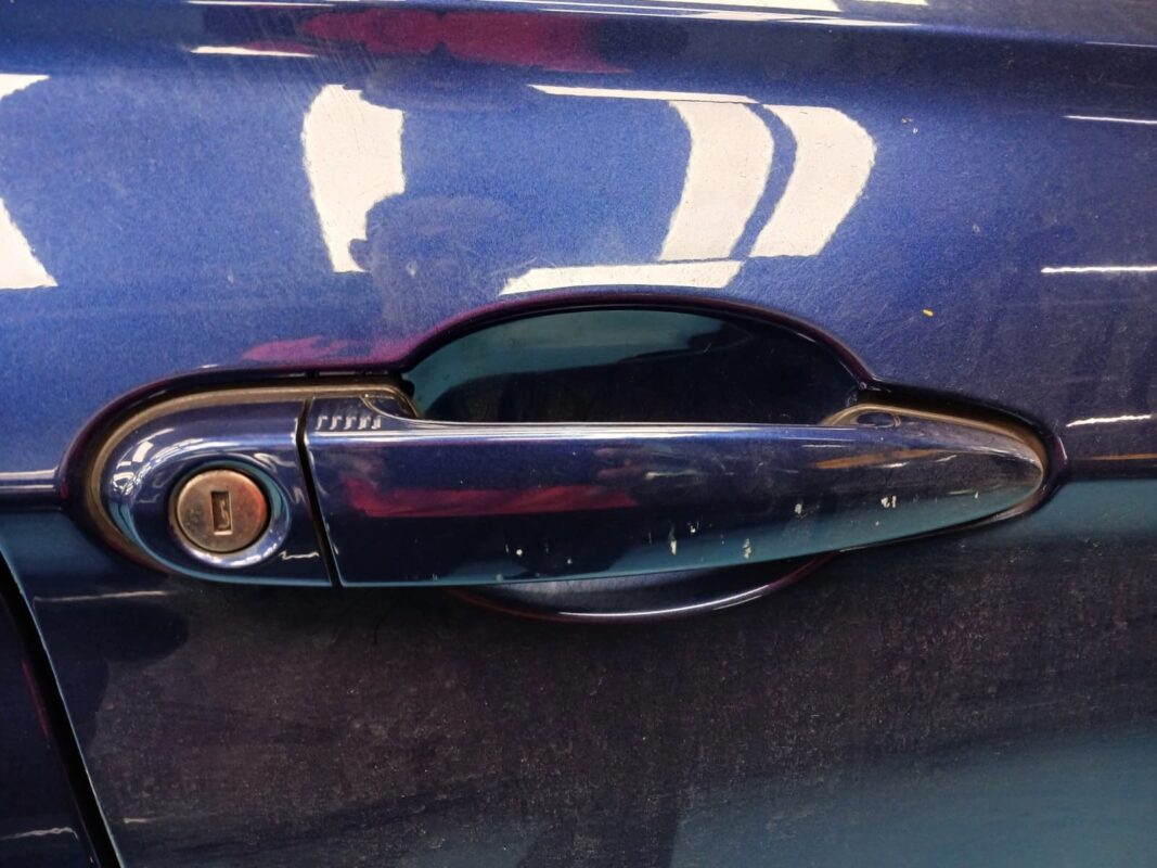 The BMW 318i from another angle at intake, showing the scratched paintwork.