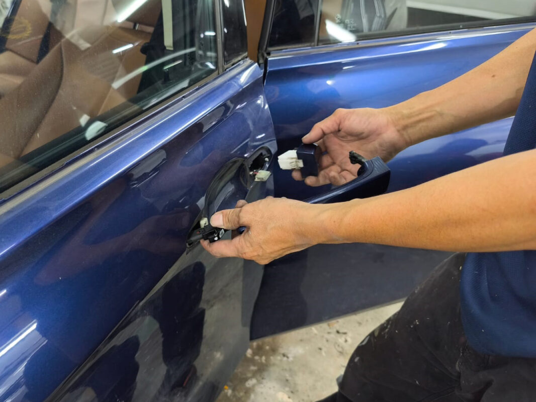 Car parts being dismantled from the BMW 318i in preparation for spraying.