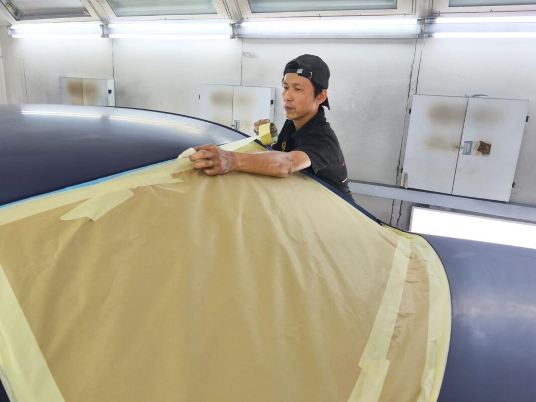 Non-painted surfaces being masked off on the BMW 318i.