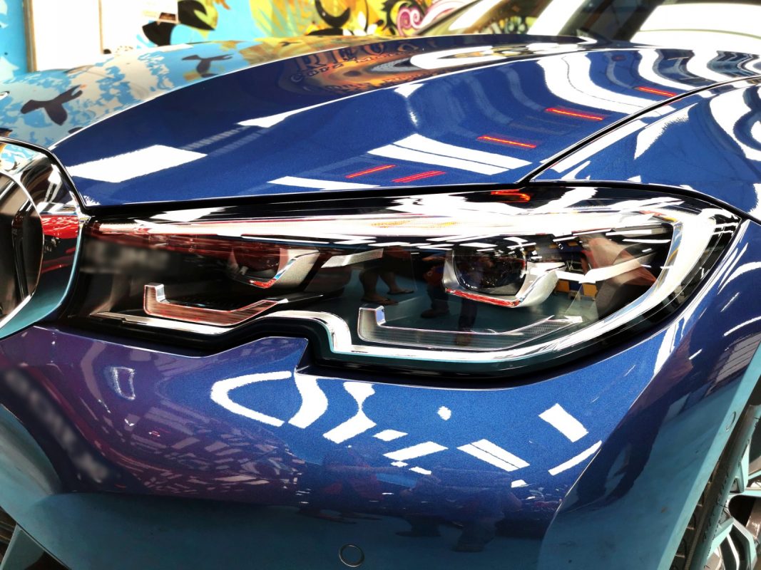 The 318i's coated paintwork showing clean reflections.