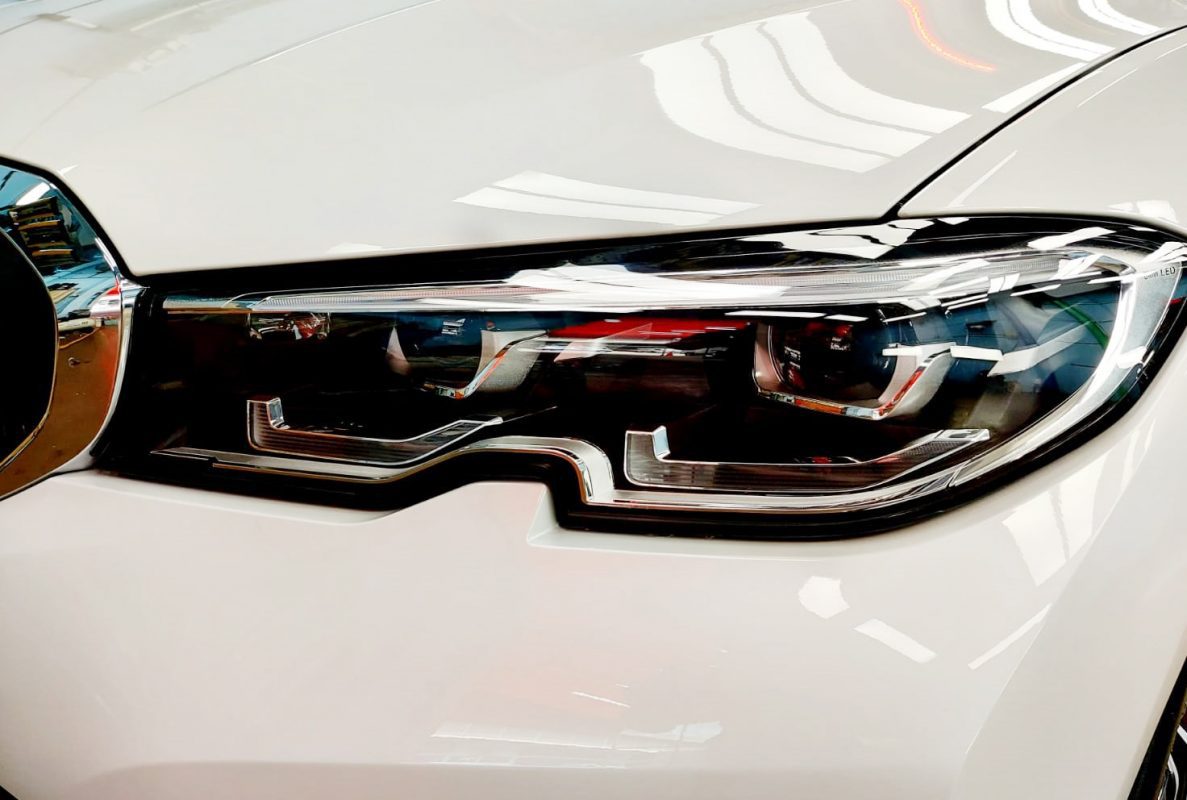 The 318i's coated paintwork showing clean reflections.