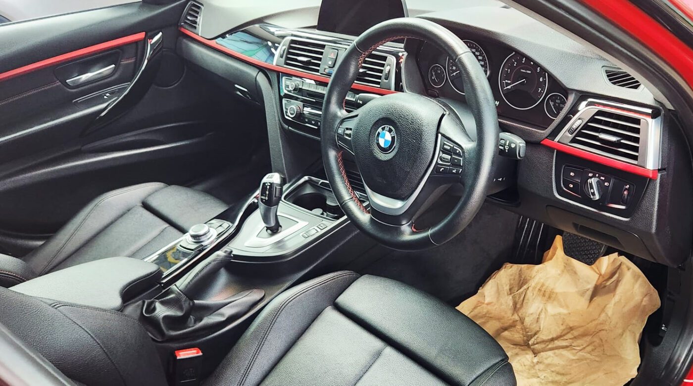 The BMW 318i parked in the workshop, freshly coated.