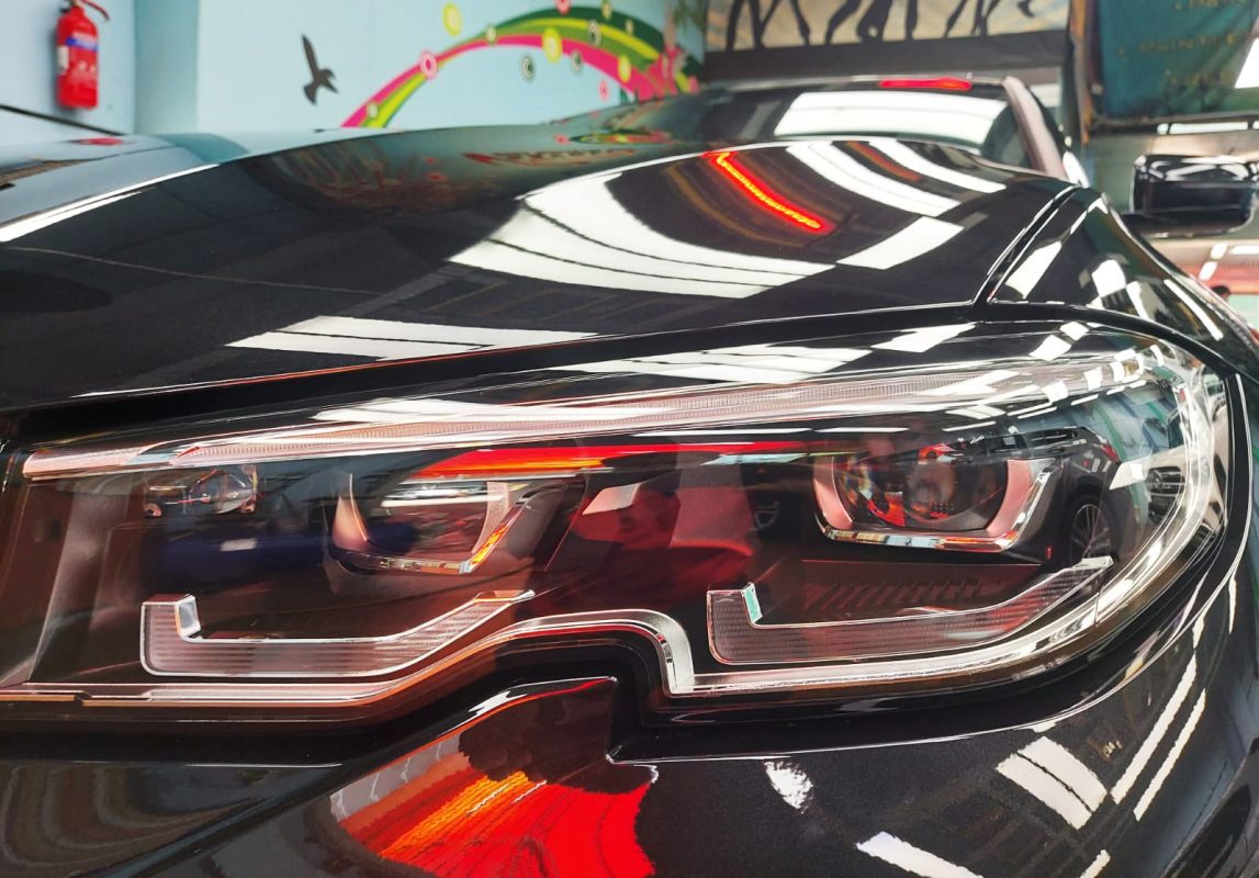 The 318i's coated paintwork showing clean reflections.