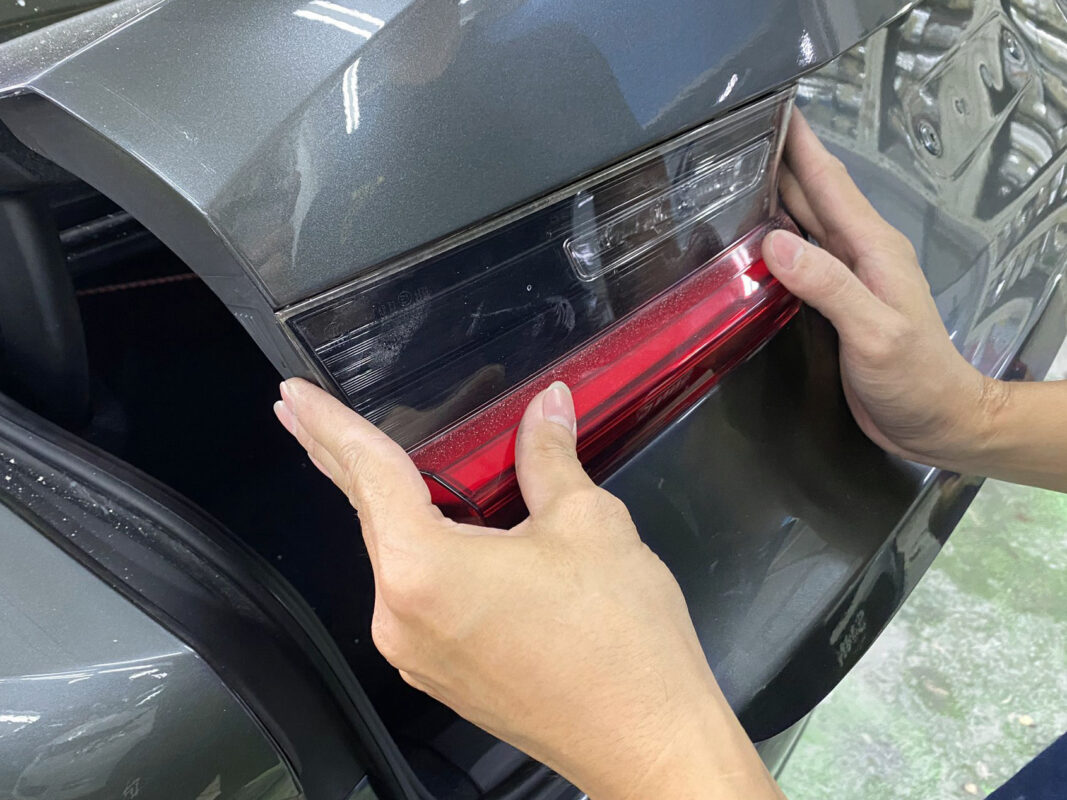 Machine-polishing the BMW 320i's panels to bring up a deep gloss after painting.