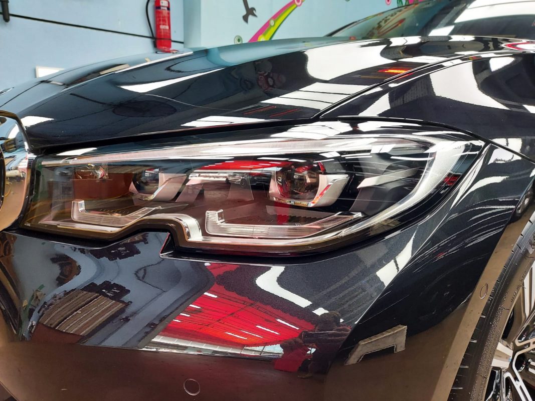 The 320i's coated paintwork showing clean reflections.
